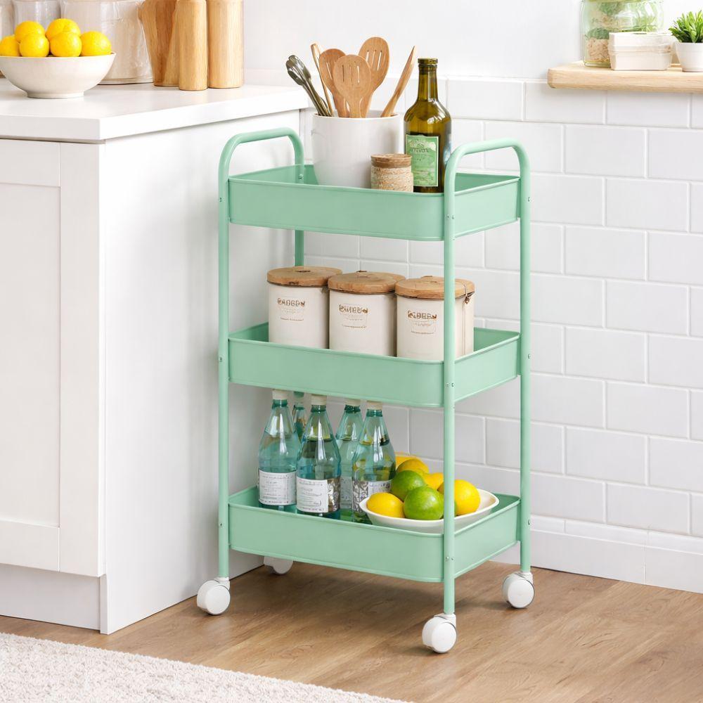 carrello multiuso salvaspazio a tre piani - foto 2 Carrello turchese a tre ripiani in uso in cucina con bottiglie, limoni e contenitori