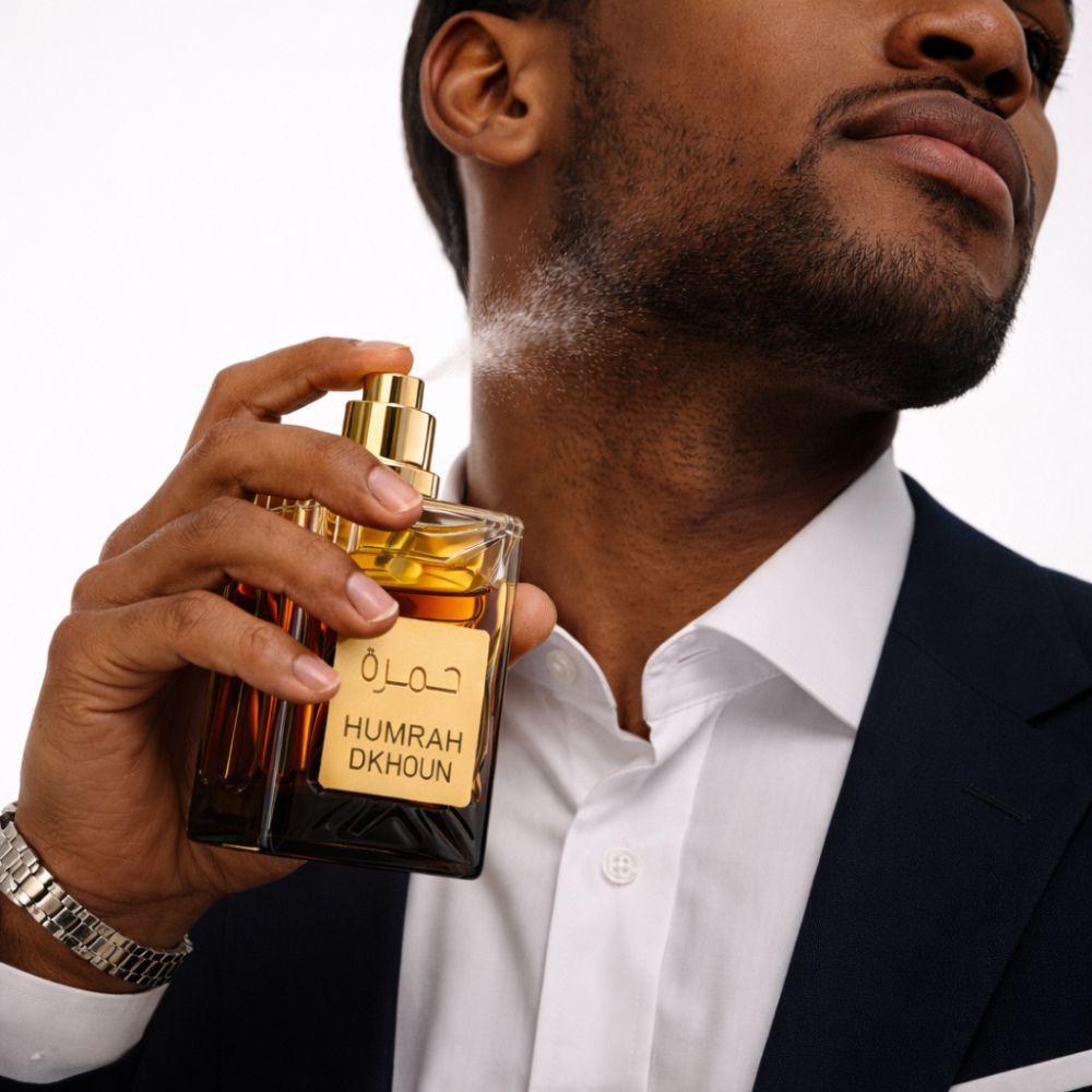 humrah eau de parfum 100 ml profumo orientale - foto 3 Uomo che indossa camicia bianca con flacone di profumo Humrah Eau De Parfum giallo dorato in mano