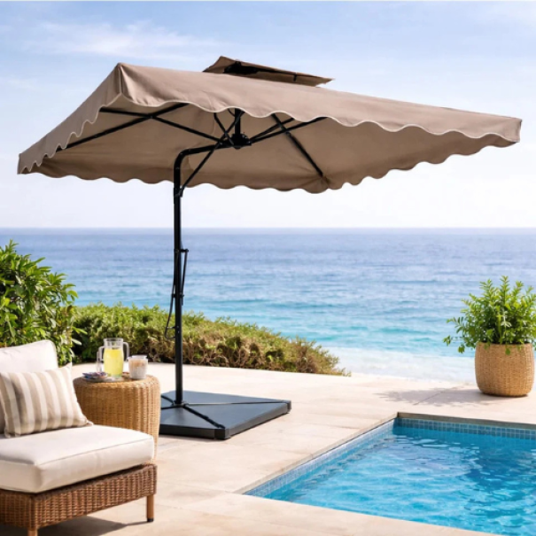 Ombrellone beige in contesto d'uso a bordo piscina con sdraio, piante in vaso e vista sul mare